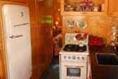 Restored fridge, gas stove and kitchen cabinets in 1938 Kozy Coach Trailer